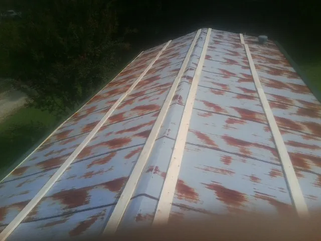 Rusted metal roof panels with new wood purlins before replacement — Storm Damage Roof Repair in Rowland by Roofing Brothers